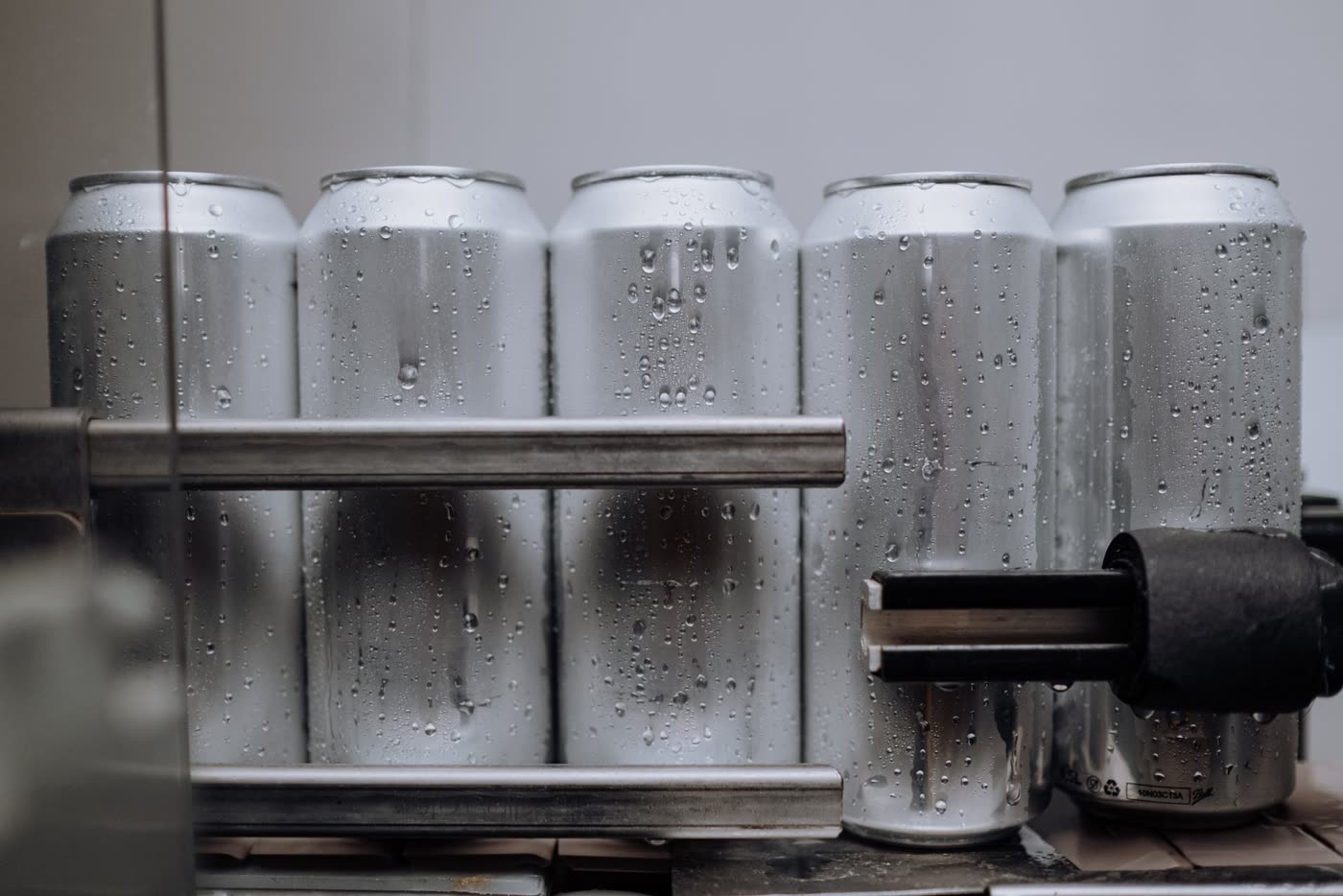 Freshly filled aluminum cans beaded with condensation on a canning line